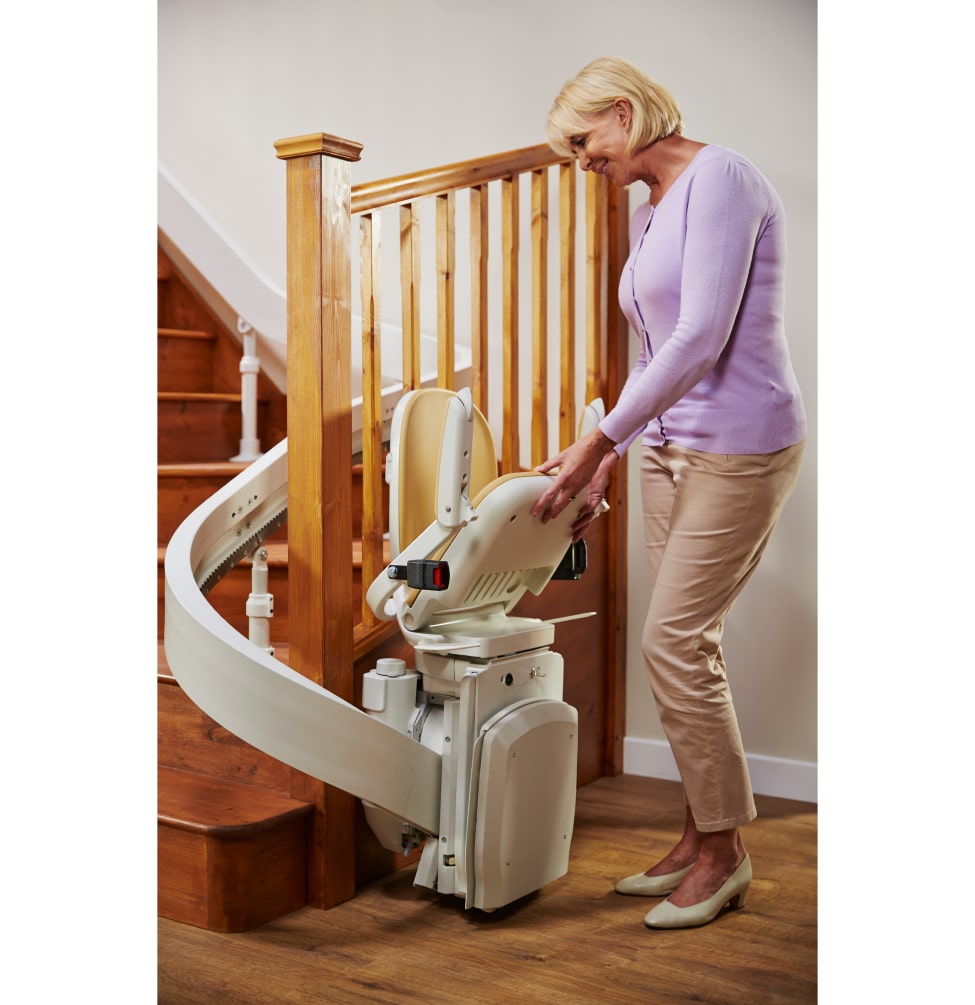 Lady folding up Acorn 180 stairlift