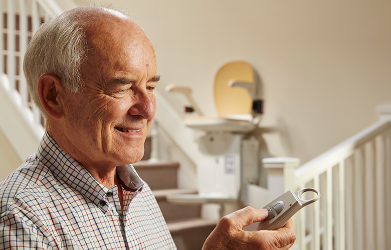 Man Using Remote Control For Stairlift To Move